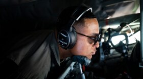U.S. Air Force Tech. Sgt. Tyler Simmons in an airplane with headset and sunglasses on.