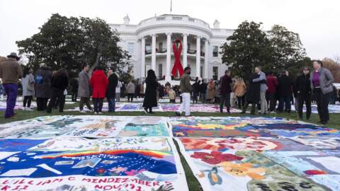 AIDS survivors, their families and advocates look at the display of AIDS Memorial quilts spread over the South Lawn of the White House during a ceremony to commemorate World AIDS Day, Sunday, Dec. 1, 2024, in Washington. (Manuel Balce Ceneta/AP)