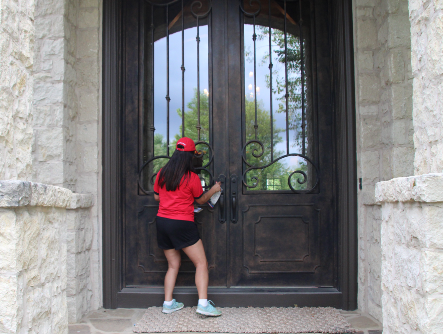 Adrienne Vallejo Foster knocks on doors in an Overland Park neighborhood in late July.