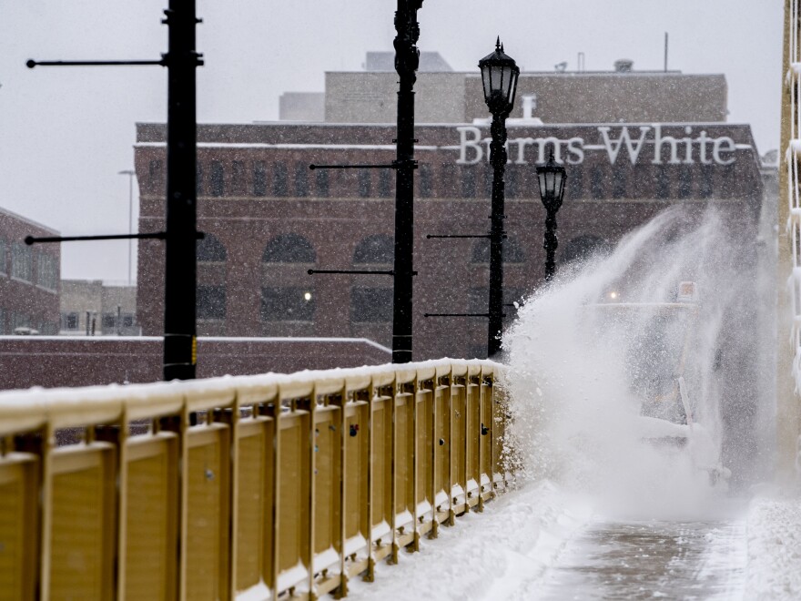 A vehicle clears snow from the pedestrian sidewalk over the Andy Warhol Bridge, Downtown Pittsburgh, Monday, Jan. 17, 2022.