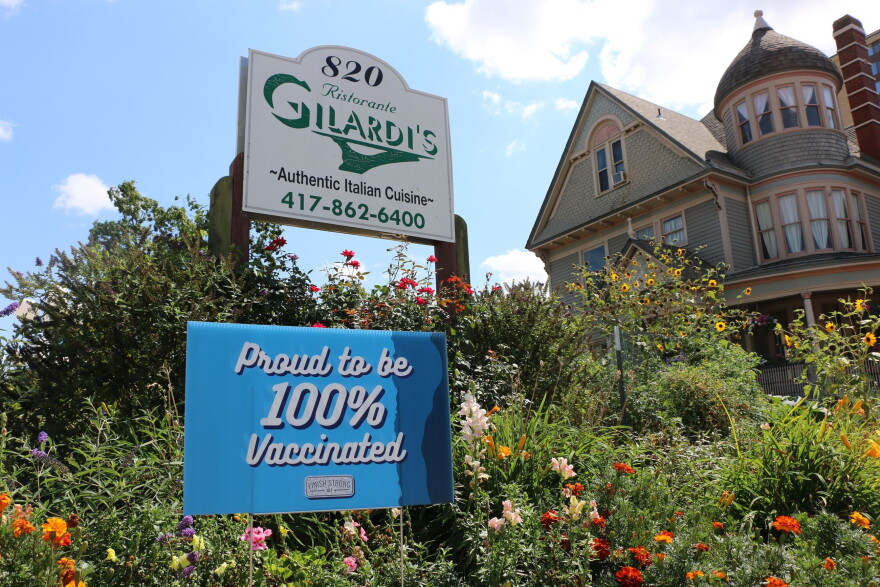 A sign is displayed in front of a local business touting its staff's vaccination rate