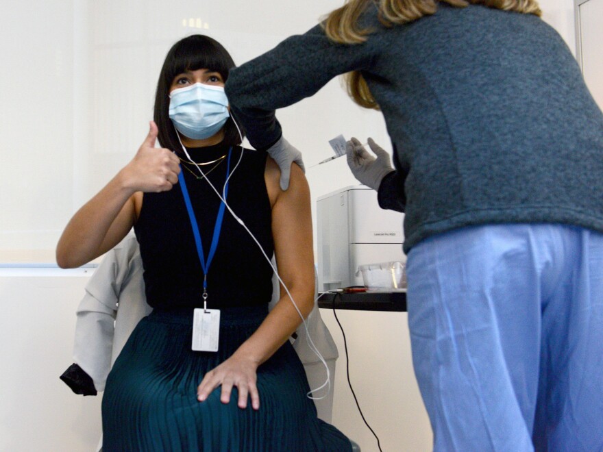 Dr. Gabriela Andujar-Vazquez of Tufts New England Medical Center in Boston receives the very first COVID-19 vaccine given to the hospital's frontline workers on Dec. 15, 2020.