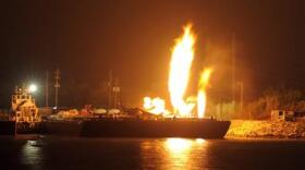 Fire burns aboard two fuel barges along the Mobile River after explosions sent three workers to the hospital Wednesday April 24, 2013. (AP Photo John David Mercer)