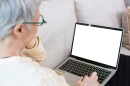 This stock image shows a female senior citizen using a laptop computer.