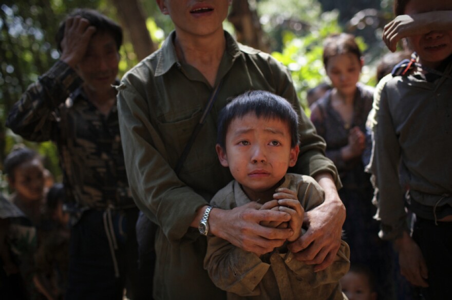 Hmong villagers break down in tears at their hidden village in Laos on Nov. 27, 2007. The villagers are regular targets of the Lao People's Army for their roles in collaborating with the CIA during the Vietnam War. Their families have had limited contact with Westerners since 1975.
