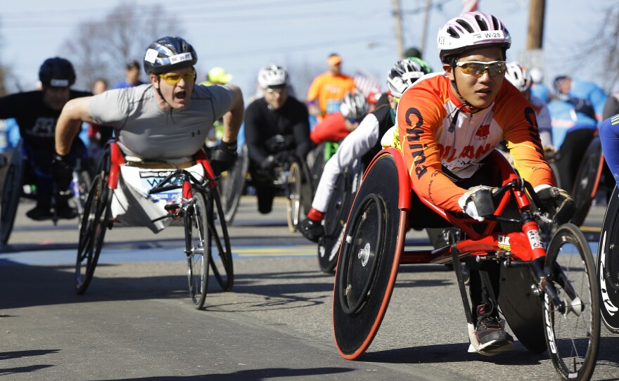 Participants in the wheelchair division of the marathon cross the starting line in Hopkinton.