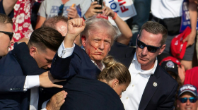 Republican candidate Donald Trump is seen with blood on his face surrounded by secret service agents as he is taken off the stage at a campaign event at Butler Farm Show Inc. in Butler, Pennsylvania, July 13, 2024. Donald Trump was hit in the ear in an apparent assassination attempt by a gunman at a campaign rally on Saturday, in a chaotic and shocking incident that will fuel fears of instability ahead of the 2024 US presidential election. The 78-year-old former president was rushed off stage with blood smeared across his face after the shooting in Butler, Pennsylvania, while the gunman and a bystander were killed and two spectators critically injured.