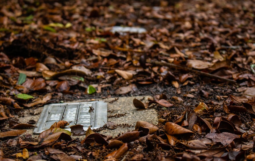 Close-up of a metal grave marker in the ground