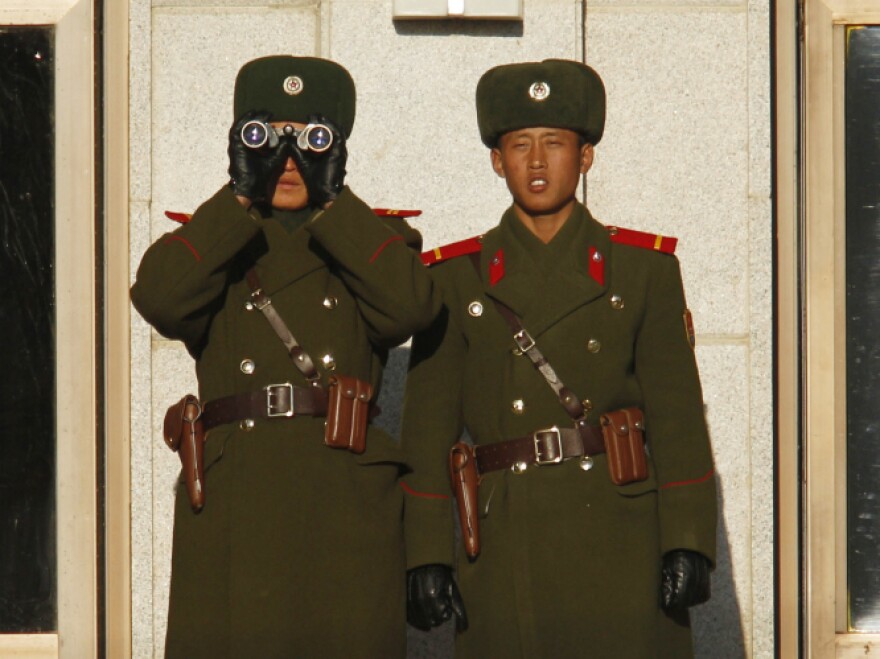 North Korean soldiers watch the South Korean side of the demilitarized zone on Thursday. North Korea has tightened security and put troops on alert since the announcement of Kim's death.