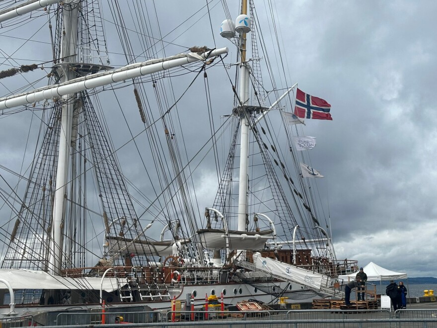 A tall ship docked on a cloudy day.