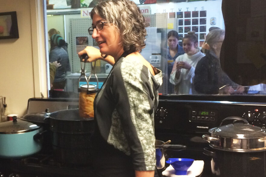 Kendra Brewer pulls a jar of apples from a hot water bath canner during a canning demonstration at Mother Hubbard's Cupboard.