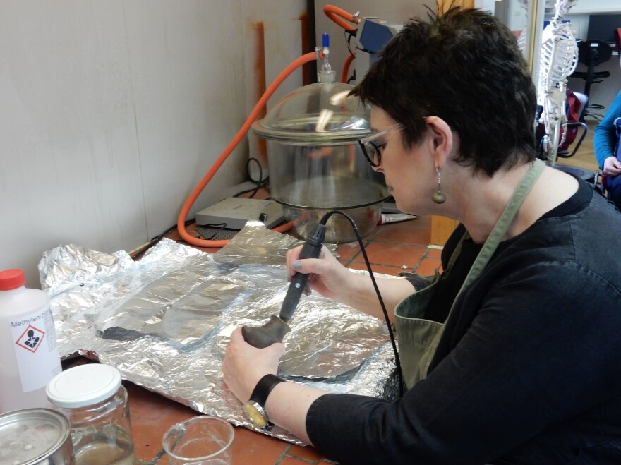 Archaeologist Julie Dunne of the University of Bristol examines one of the prehistoric feeding vessels that she says were used as ancient baby bottles.