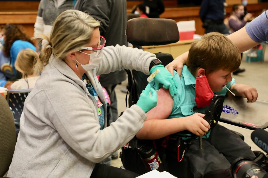 Nurse Denise Shanks, gives Gus, age 10, his COVID vaccine at Cincinnati Children's Hospital on Wednesday, November 3, 2021, the first day the shots were available.