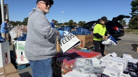 Pastor Joe McGourn with the Alive Dream Center in Suffolk and Dana Carhart with the Foodbank of Southeastern Virginia and the Eastern Shore bag pantry staples for the food distribution event Oct. 17.