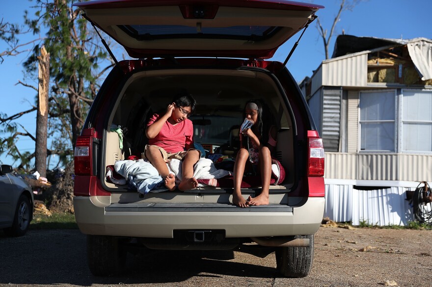 PANAMA CITY , FL - OCTOBER 13: Carlos Deviana and his sister Jessica Deviana sit in the back of their father's SUV which they are using as a bedroom after hurricane Michael destroyed their home as it passed through the area on October 13, 2018 in Panama City, Florida. The hurricane hit the Florida Panhandle as a category 4 storm causing massive damage and claimed the lives of 17 people. (Photo by Joe Raedle/Getty Images)