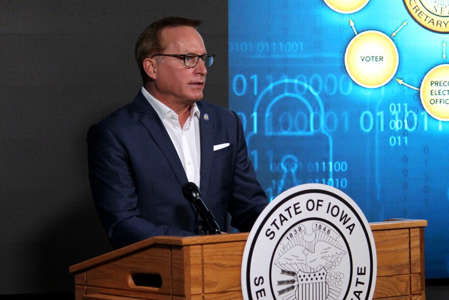 Iowa Secretary of State Paul Pate stands behind a podium as he speaks to reporters about election security safeguards.