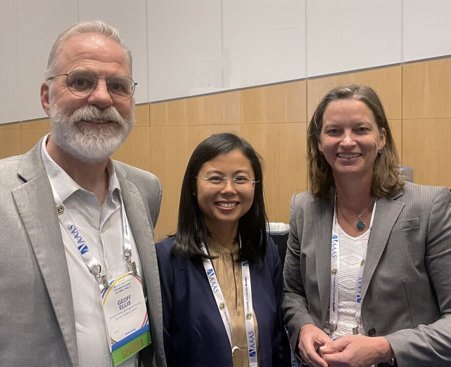 Colorado scientists Geoffrey Ellis, Mengli Zhang and Alexis Templeton smile for a photo together indoors. They all wear professional attire.