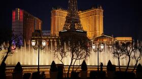 In this Nov. 19, 2020, file photo, a woman watches the fountains at the Bellagio hotel-casino along the Las Vegas Strip in Las Vegas.