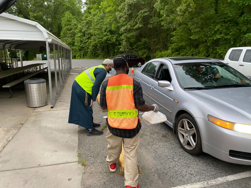 Islamic Center of Charlotte's Imam Muhammad Khan and a volunteer hand out meals to a family