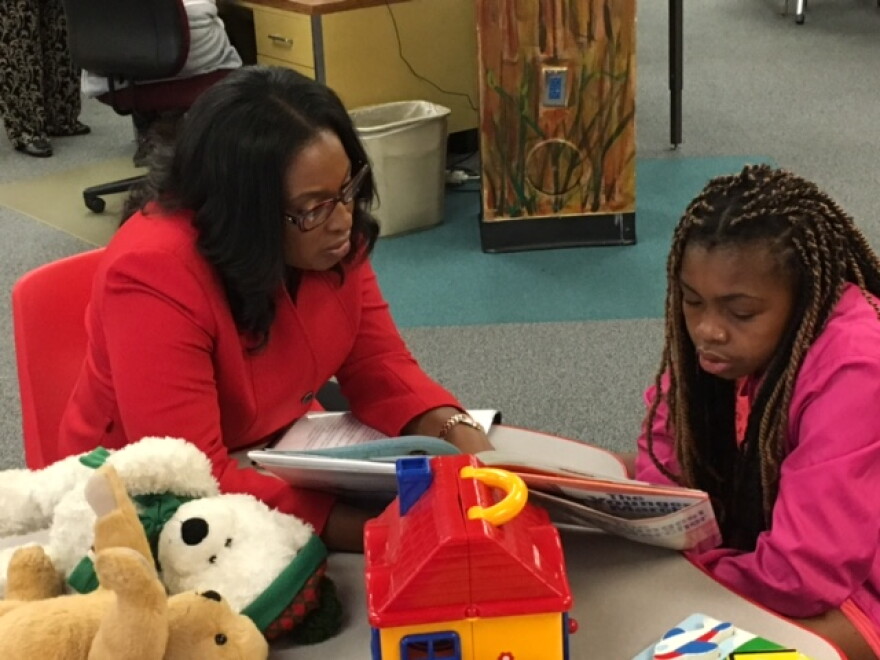 Mayor Warren reads with a young patron at the library