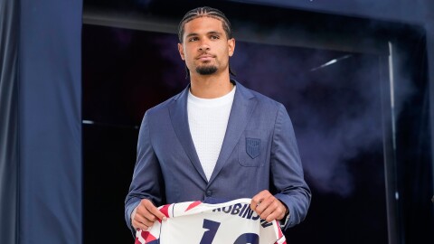 man carries a soccer jersey with his name and number.