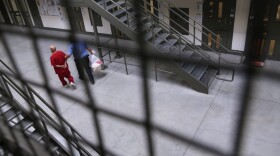 A guard escorts an immigrant detainee from his 'segregation cell' back into the general population at the Adelanto Detention Facility, a private detention center operated by Florida-based GEO Group. (John Moore/Getty Images)