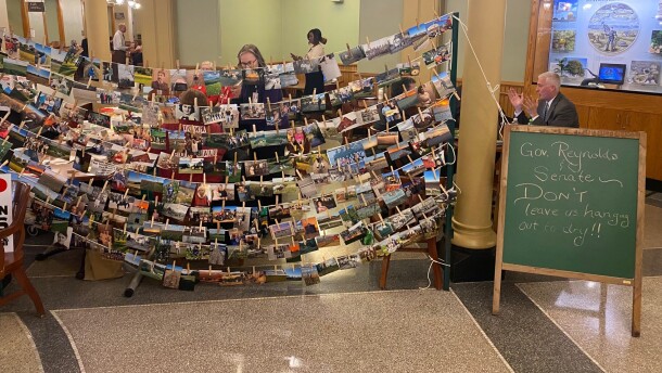 a sign in the state capitol says "governor reynolds and senate, don't leave us hanging out to dry!" 