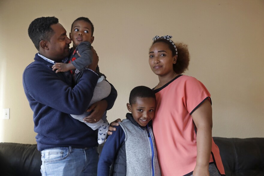 In this photo taken Sept. 24, 2019, Yonas Yeshanew, left, who resigned as Ethiopian Airline's chief engineer this summer and is seeking asylum in the U.S., poses with his family, including wife Tigist Hailu and sons Nathan Yonas, 1, and Yoel Yonas, 5
