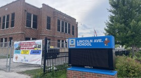 A banner hung outside Lincoln Avenue Elementary reads in Spanish, "Let's have a safe summer. Let children play in clean neighborhoods free of violence." The school was destroyed by a fire on the night of June 29, 2026.