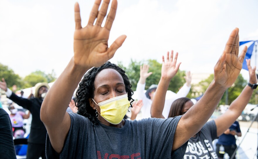 Marvette St. Clair from Stonecrest, Ga., puts her hands up as a prayer is led at the end of the rally.