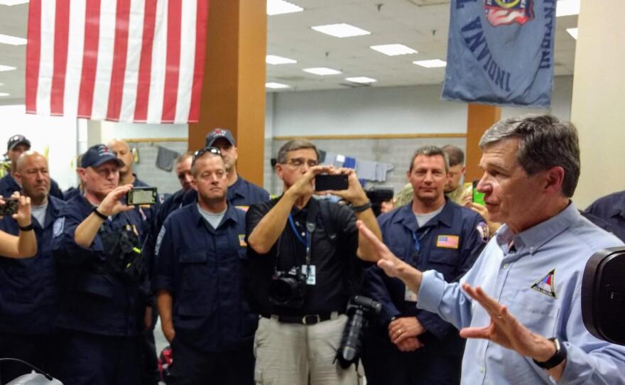 Roy Cooper talks with out-of-state emergency workers at a temporary dormitory in Wilmington Tuesday. 