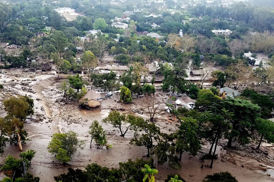 This aerial photo provided by the Santa Barbara County Fire Department shows mudflow and damage to homes in Montecito, Calif., Wednesday, Jan. 10, 2018. Anxious family members awaited word on loved ones Wednesday as rescue crews searched grimy debris and ruins for more than a dozen people missing after mudslides in Southern California on Tuesday destroyed over a 100 houses, swept cars to the beach and left more than a dozen victims dead. (Matt Udkow/Santa Barbara County Fire Department via AP)