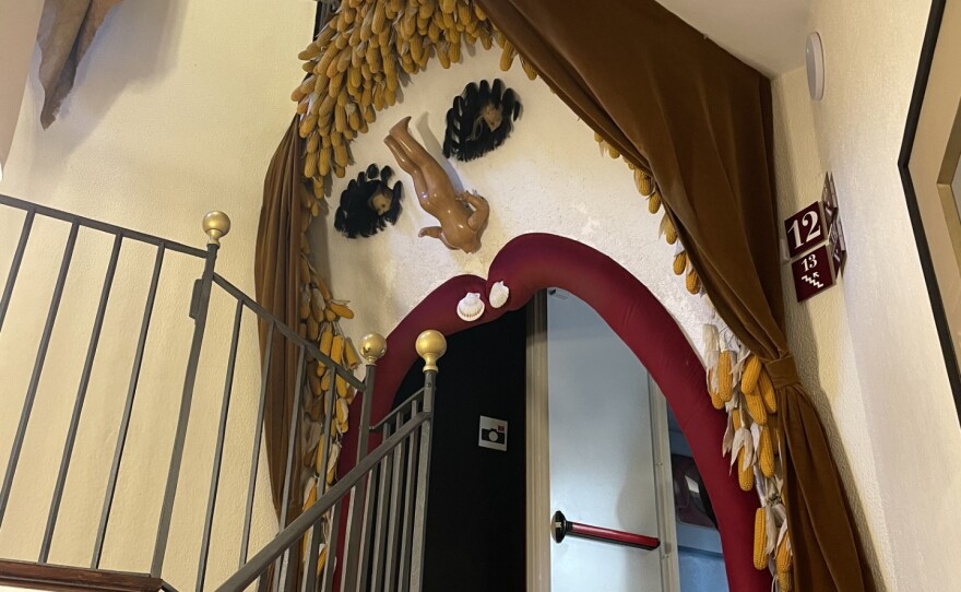 A large face is built into the wall at the top of a set of stairs.