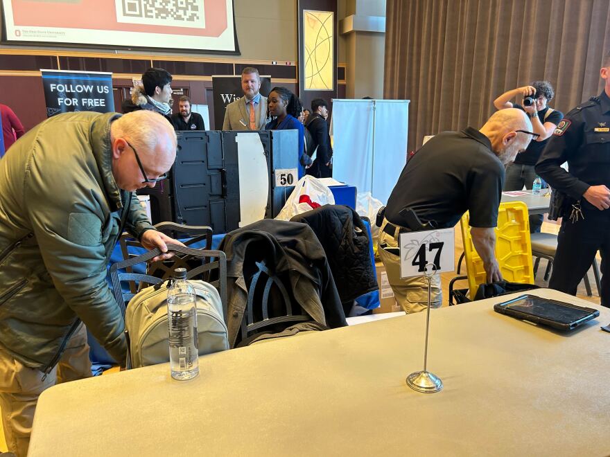 Two men packing up bags.