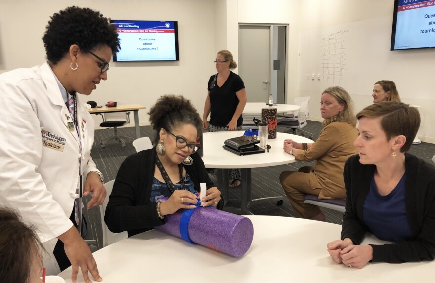 Dr. Laurie Punch, left, teaches a Stop the Bleed STL participant how to use a tourniquet to control severe bleeding.