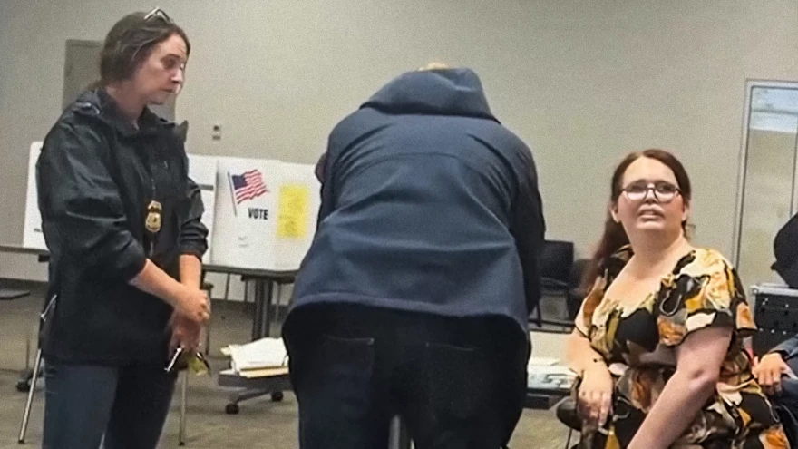 Paigelynne Gonyea, at right, refusing to sign a warning letter delivered by two federal immigration agents as she worked at a polling place in Syracuse, June, 2026.