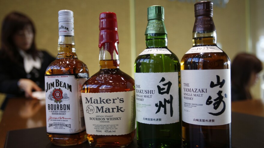 The Japanese drinks company Suntory plans to buy Beam Inc., which includes Jim Beam and Maker's Mark bourbon. They are shown next to Suntory's Yamazaki and Hakushu whiskies at Suntory headquarters in Tokyo on Tuesday. The deal makes Suntory one of the world's leading drinks companies in an industry where a handful of companies increasingly dominate the global market.