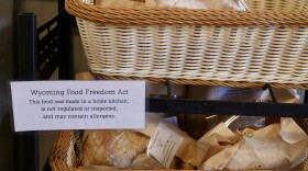 Loaves of bread sit in a basket. A note in front of them explains that they were made in a home kitchen that hasn't been inspected.