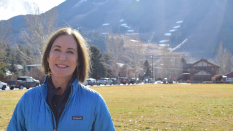 Photo of woman standing in front of ski hill