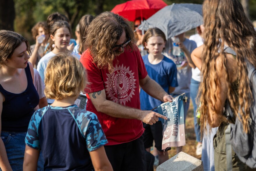 Keith Crippen, a member of the International Order of Odd Fellows, chats with students during a tour of the cemetery. Crippen and his fellows have been volunteering to repair and preserve gravestones.