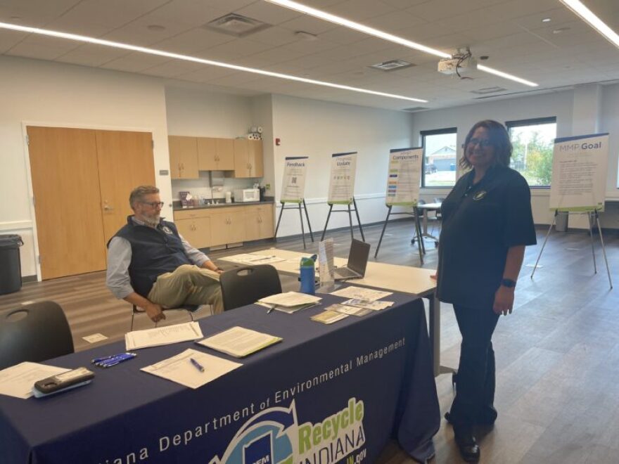 IDEM Recycling Market Development Program Manager Deanna Garner stands by an Indiana Department of Environmental Management booth as a colleague sits. Agency staff held an open house in Johnson County on Sept. 3, 2025 for an in-progress materials management plan.