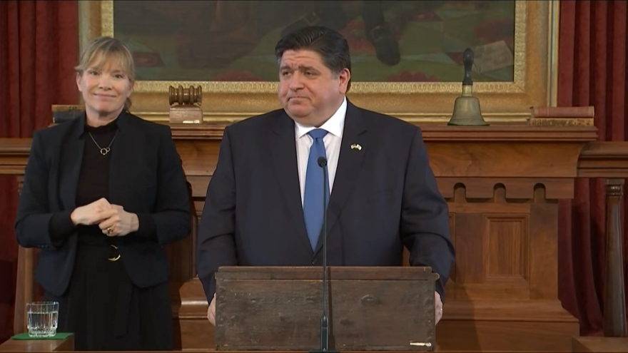  Governor J.B. Pritzker and his ASL Interpreter speaking from the dais of the Old State Capitol. 