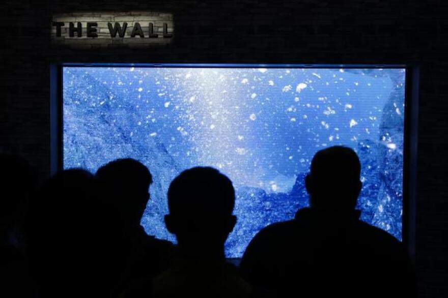 Attendees look at Samsung's "The Wall" modular television at CES International Wednesday, Jan. 10, 2018, in Las Vegas.