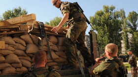 German troops serving in the NATO-led peacekeeping mission (KFOR) in Kosovo unload sandbags as part of the reinforcement of KFOR troops in the town of Mitrovica on September 28, 2011.
