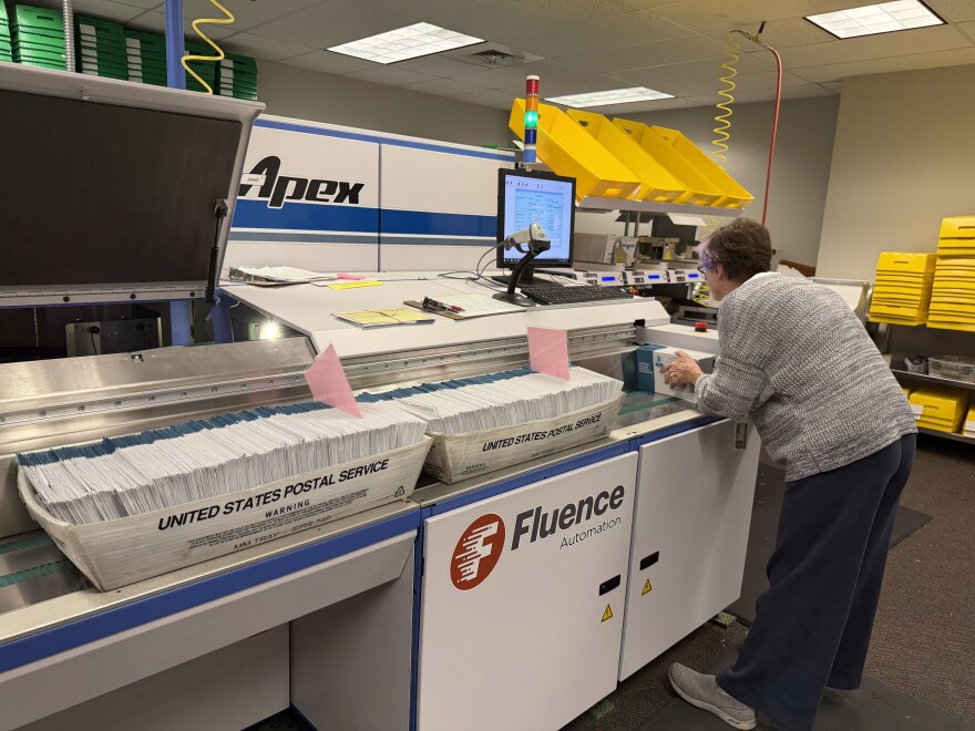 A Lane County Elections Office employee runs ballots through a signature verification machine, May 15, 2026.