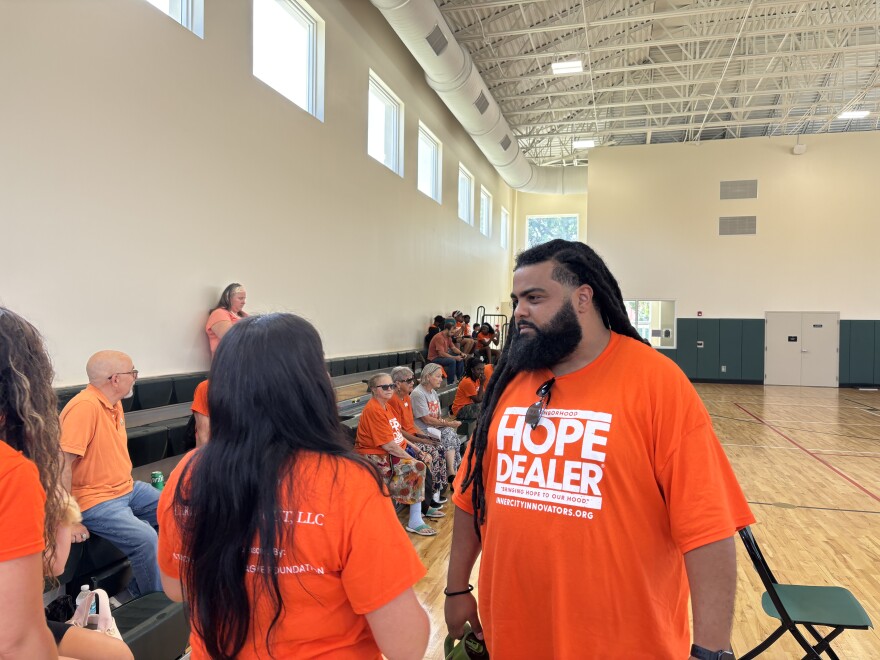 David "Dee" Rae (right) speaks with a rally attendee on June 6, 2026 at Coleman Park's gymnasium. Rae helps mentor young men in violent neighborhoods to help them make better choices.