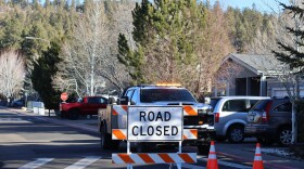 The blocked road to a neighborhood in Flagstaff, Arizona, where police say a man opened fire at officers is seen Thursday, Feb. 5, 2026.