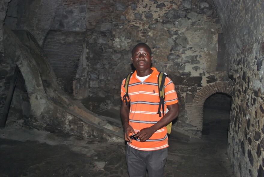 George Mwinnyaa stands in a slave castle dungeon for male captives in Ghana.