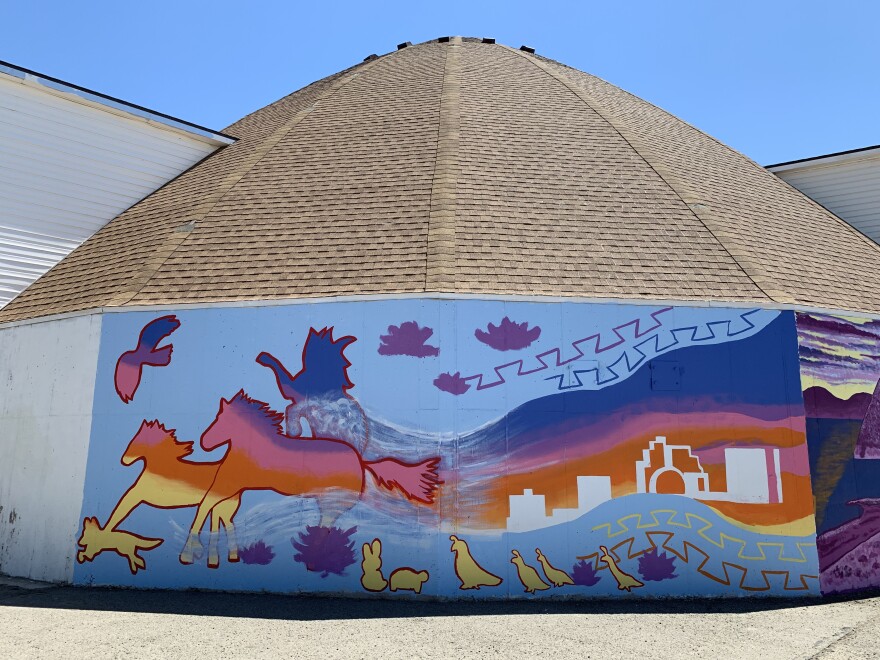 A mural with the river, wild horses, birds and buildings on it.