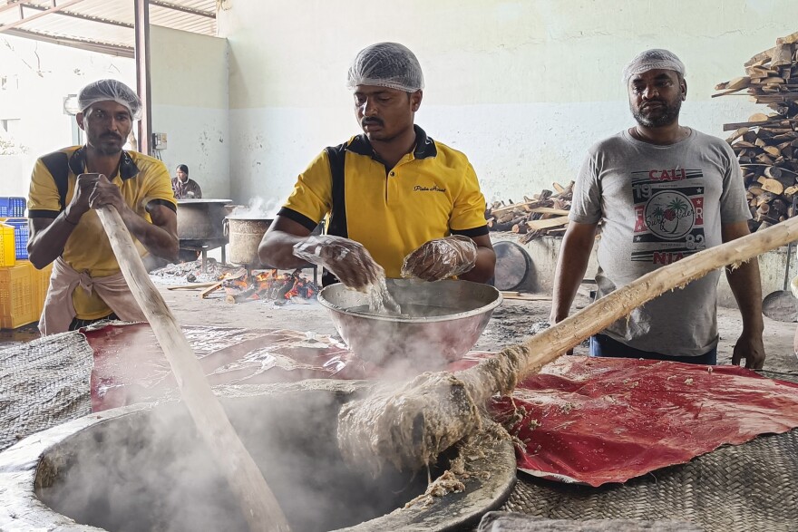 Workers pound the steaming mixture of meat, lentils, wheat and spices with long wooden paddles to give the haleem its signature smooth texture.